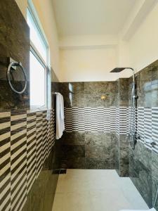a bathroom with a shower with a glass door at SKY Heaven in Weligama