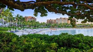 a view of a beach with palm trees and buildings at Your Resort Home Walk to Disney & Beach in Honokai Hale