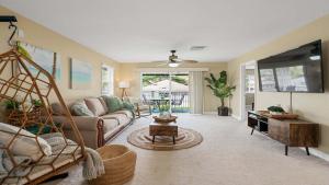 a living room with a couch and a tv at Your Resort Home Walk to Disney & Beach in Honokai Hale