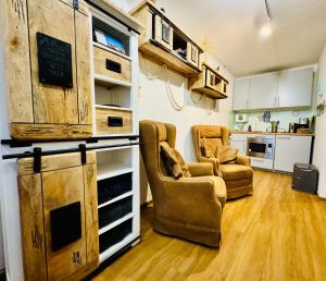 a living room with two chairs and a kitchen at Lütte Wulke 8, wo Träume Weite finden in Wunstorf