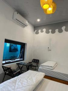 Văn LâmThe Mountain Homestay & Cafe的有两张床、一张桌子和一扇窗户的房间