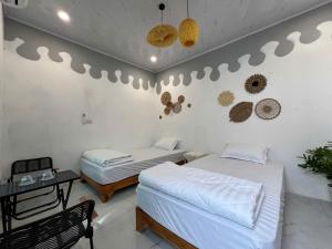 Văn LâmThe Mountain Homestay & Cafe的一间设有两张床和一张桌子的房间