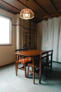mesa de comedor con sillas y lámpara de araña en chidori4 伝統的な銭湯の上にある宿広々空間 銭湯無料体験 西九条駅 千鳥橋 USJ, en Wada