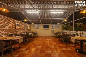 un ristorante con tavoli e sedie e un muro di mattoni di StayVista's Lush Villa - Rustic-Meets-Modern Interiors, Pool, Jacuzzi & Indoor activities a Wādhiware