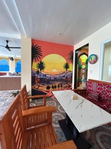 a dining room with a painting on the wall at Morocco Hotel El Nido in El Nido