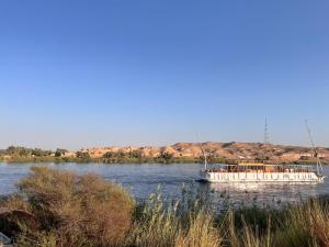 a white boat on the water on a river at Nile SE Felucca nile cruise private tour in Naj‘ al ‘Amrāb