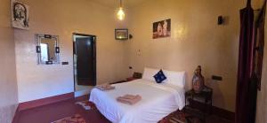 Un dormitorio con una cama blanca con toallas. en Chez Brahim vue panoramique, en Aït Ben Haddou