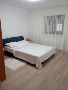a bedroom with a bed and a wooden floor at Casa Camelia in Craiova