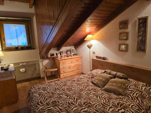a bedroom with a bed and a dresser and a window at La Casa di Giò -GALLIO CENTRO- in Gallio