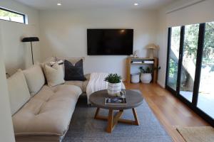 una sala de estar con un sofá y una mesa en Driftwood Studio, en Mount Martha