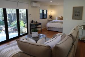a living room with a couch and a bed at Driftwood Studio in Mount Martha