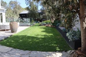 un jardín con césped junto a un edificio en Driftwood Studio, en Mount Martha