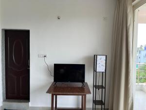 a room with a table with a television and a door at The Ashvem Horizon in Mandrem