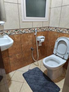 a bathroom with a toilet and a sink at Delightful Private Rooms with Garden View in Sharjah +4 photos