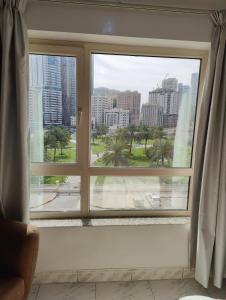 a window with a view of a city at Delightful Private Rooms with Garden View in Sharjah