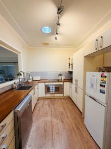 a kitchen with white appliances and wooden floors at Marley's at Boma in Bomaderry