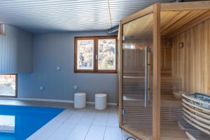 a bathroom with a glass shower and blue walls at Chalet La Tanière 14 Pers - piscine chauffée et sauna - Vars Saint Marcellin in Vars