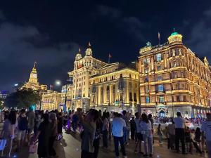 a crowd of people standing in front of a building at Downtown, 3B2B, near Pedestrian St, the Bund, Pearl Tower in Shanghai