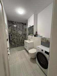 a bathroom with a toilet and a stone wall at Central monarch 1 P&P Residence in Timişoara