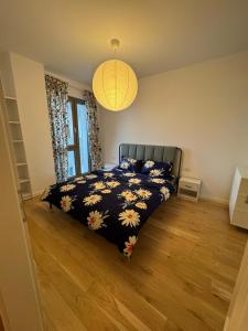 a bedroom with a bed with a black blanket with flowers at Central monarch 1 P&P Residence in Timişoara +4 photos