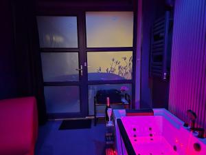 Studio Balnéo Bord de mer Fouras - 800m de la plage في فورا: حوض استحمام وردي في غرفة مع نافذة +40 صورة