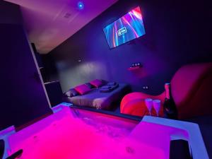 Studio Balnéo Bord de mer Fouras - 800m de la plage في فورا: غرفة أرجوانية مع سرير وتلفزيون