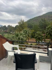 a balcony with white chairs and a view of a mountain at Eldorado Hotel in Kumluca