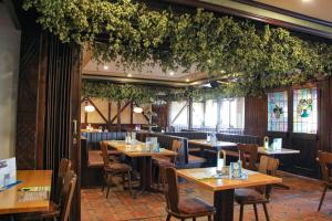 a restaurant with wooden tables and chairs and plants at Gasthaus Wollscheid in Trier
