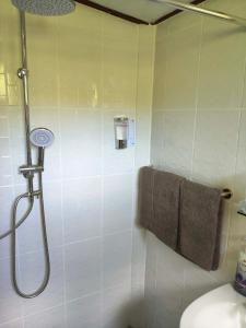 a bathroom with a shower with a toilet and towels at RATTHANATHON Farm in Khao Kho