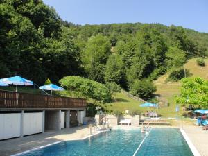 Sankt Nikola an der Donau圣尼古拉公寓的游泳池,游泳池里有人坐在椅子和遮阳伞上