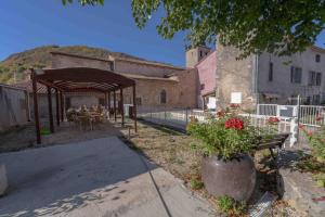 eine Außenterrasse mit einem Tisch und einem Pavillon in der Unterkunft Mobil-home 6 personnes in Roquefeuil + 12 Fotos