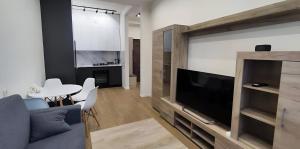 a living room with a couch and a tv and a table at CozyNest Apartment In Yerevan, Center in Yerevan