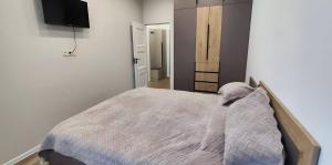 a bedroom with a bed and a flat screen tv at CozyNest Apartment In Yerevan, Center in Yerevan