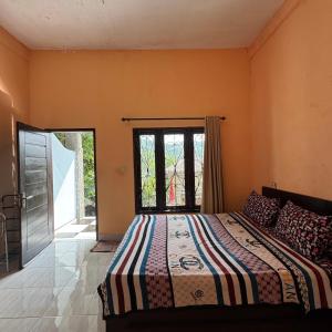 Un dormitorio con una cama y una ventana en Sunrise Bukit Asam Home Stay, en Kuta Lombok 2 fotos más