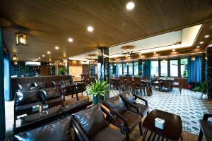 ein Restaurant mit Ledersofas, Tischen und Stühlen in der Unterkunft Tam Coc Holiday Retreat in Ninh Bình
