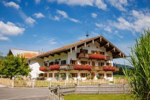 a building with flowers in front of a fence at Knoglerhof inkl. Chiemgaukarte in Ruhpolding