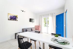 a living room with a white table and chairs at Villa El Greco Apartments in Agia Marina Aegina