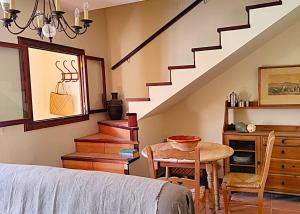 Una sala de estar con una escalera y una mesa y sillas. en Hermosa Mía, en Villaescusa de Haro