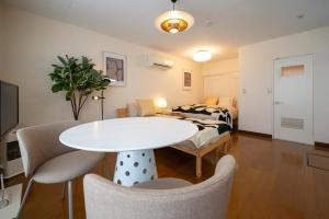 a living room with a table and a bed at BREEZE furano 山彦 霧 in Shimo-furano
