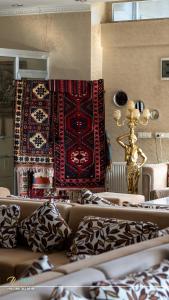 a living room with a couch and a rug on the wall at Zileli Suıtes in Hamidiye