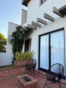 due sedie appoggiate su un patio in mattoni di fronte a un edificio di Casa 1 Beach Owl Residence a São Francisco do Sul