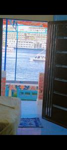 a room with a view of the water and a boat at Onaty Narty Guest house Nile view in Aswan