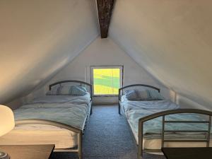 Dos camas en una habitación con ventana. en Apartments Zupan, en Šenčur