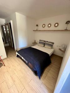 a bedroom with a bed and a wooden floor at Studio à la vallée heureuse in Sorède