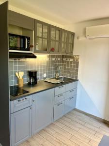 a kitchen with a sink and a microwave at Studio à la vallée heureuse in Sorède +22 photos