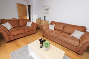a living room with two brown couches and a table at Harbour Point, Shetland Islands in Lerwick +19 photos