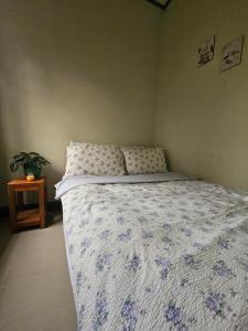 een slaapkamer met een bed met een blauw en wit dekbed bij Westlinehomestay in Puerto Princesa City +4 foto's