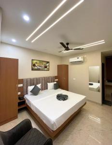 a bedroom with a large bed with a ceiling fan at The Rivanta Hotel Near Airport Road Mohali Zirakpur Chandigarh in Zirakpur