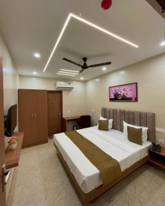 a bedroom with a large bed with a ceiling at The Rivanta Hotel Near Airport Road Mohali Zirakpur Chandigarh in Zirakpur