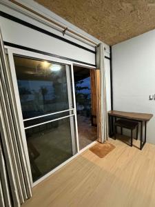 a room with a large window with a table and a bench at Tree Beach Resort in Ko Phayam